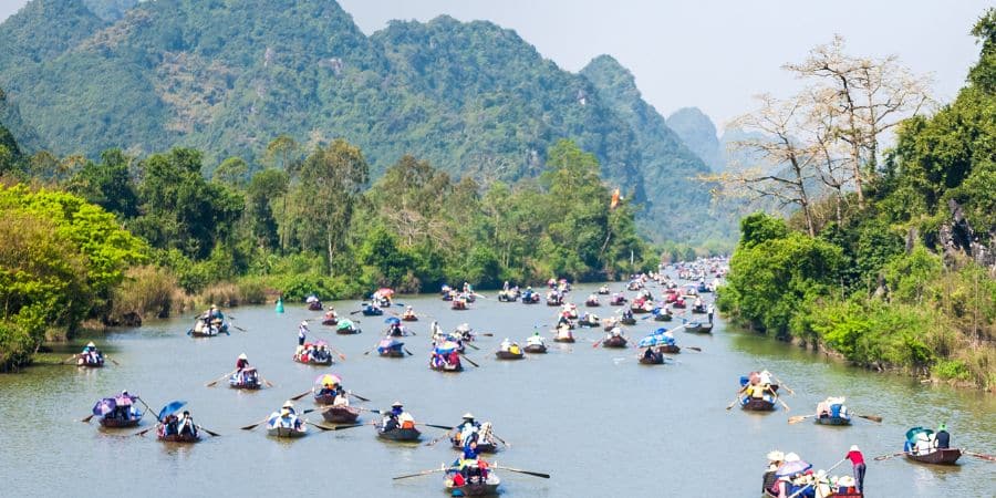 Spring at Perfume Pagoda near Hanoi with boats, limestone mountains, and lush greenery